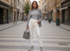 Front view of off-white slim-fit fine-knit wool jogger trousers styled with grey knitwear on a city street.