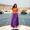 Woman in an orange top and purple linen  skirt by VVC clothing Sitia 