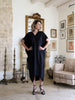 Full front view of a black plus-size kaftan by Pane Line with V-neckline, batwing sleeves and a flowing asymmetric mullet hem
