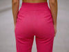 Close-up back view of pink slim-fit fine-knit wool jogger trousers showing the elastic waistband.
