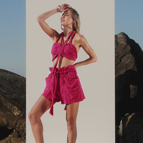 Pink festival outfit with braided shorts and halter top front standing view for summer holidays