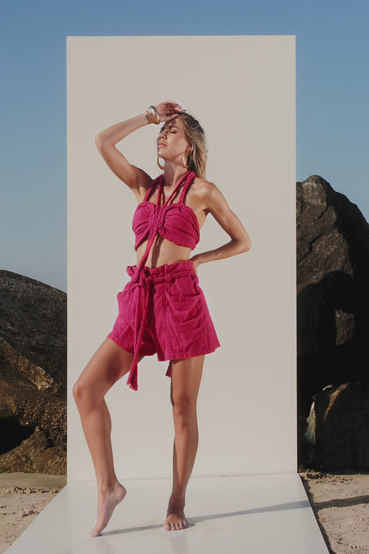 Pink festival outfit with braided shorts and halter top front standing view for summer holidays