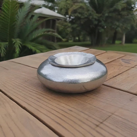 Video of a silver hammered aluminium outdoor ashtray styled for an Airbnb terrace or holiday home in Sitia.
