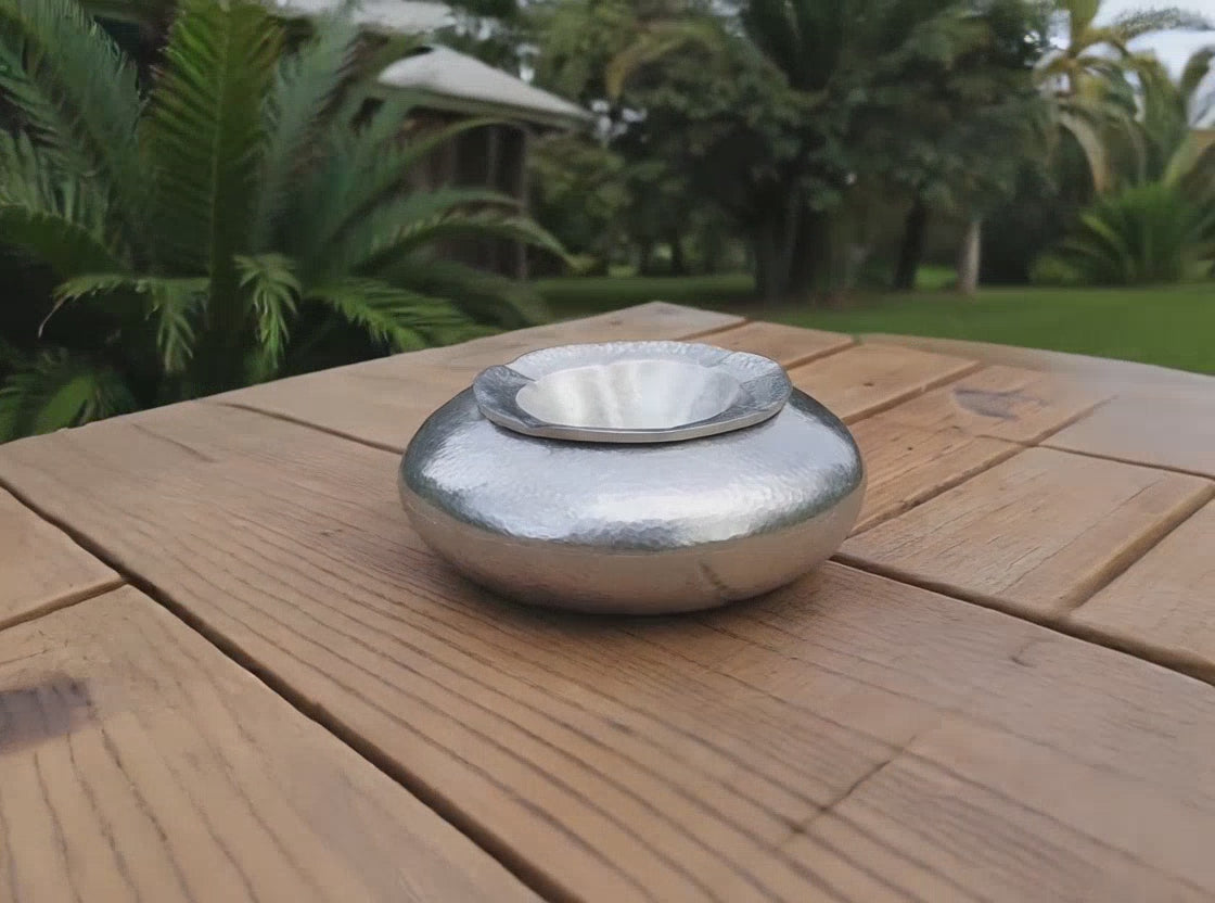 Video of a silver hammered aluminium outdoor ashtray styled for an Airbnb terrace or holiday home in Sitia.