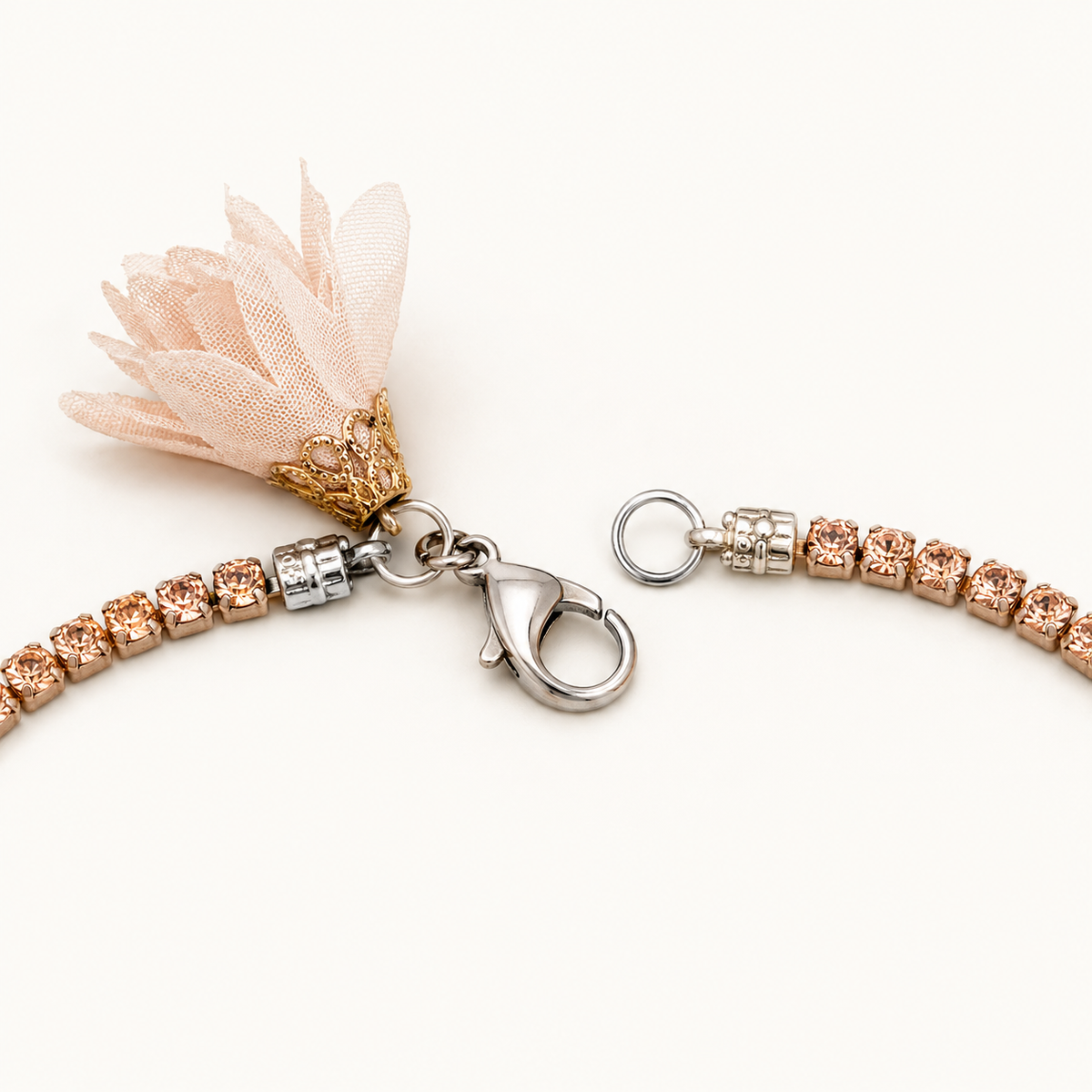 Open silver-tone lobster clasp on a rose-nude rhinestone necklace with blush textile flower from VVC Shop Sitia.