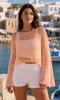 Front view of the soft peach open-knit cropped top styled with white shorts at VVC SHOP Sitia, Crete.