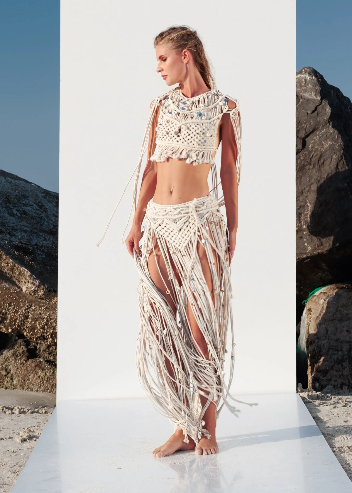 Side walking view of the Tulum macramé fringe skirt showing its flowing cotton fringes and bohemian festival style.