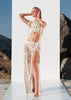 Model wearing the Tulum handmade macramé fringe wrap skirt with shells and sequins, styled as a boho festival outfit by VVC Shop Sitia Crete.