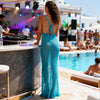 Back view of turquoise crochet maxi dress styled with halter neck tie and elegant open-back design.