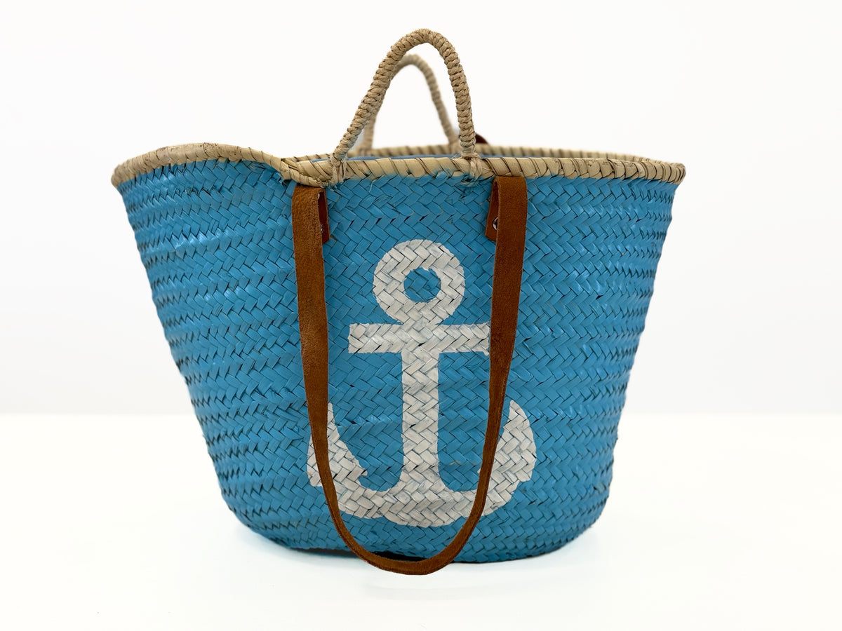 Angled view of the handmade VVC™ anchor basket featuring leather handles and woven palm leaf craftsmanship. Ideal for beach trips, shopping and travel.
