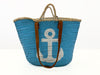 Angled view of the handmade VVC™ anchor basket featuring leather handles and woven palm leaf craftsmanship. Ideal for beach trips, shopping and travel.