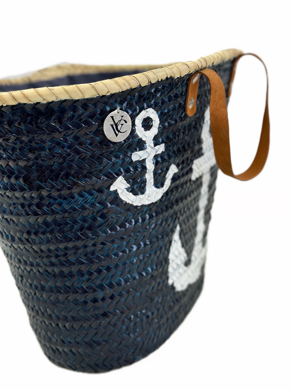 Side view of the handmade VVC™ anchor basket showcasing woven palm leaf craftsmanship and leather handles. Luxury beach bag, shopping basket and holiday travel tote on sale in Sitia, Crete.
