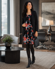 VVC backless black floral mini dress styled for a Northern European office meeting with black blazer, opaque tights and heeled ankle boots