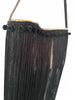 Close-up of handmade black fringe raffia shoulder bag by VVC with pompom trim, woven body and long satin fringes in Sitia Crete