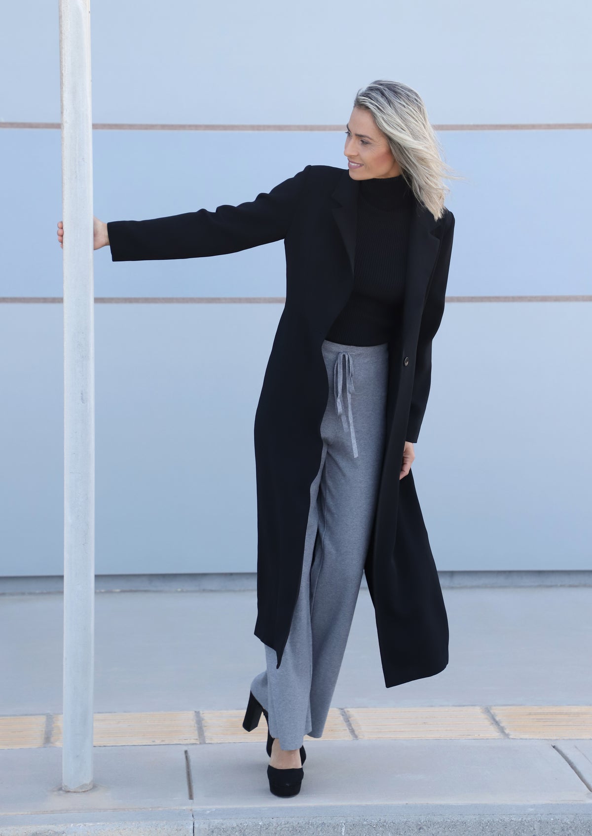 Front pose of the VVC™ black longline blazer showing its lightweight fabric and long tailored silhouette.