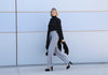 Full-length view of the VVC™ women’s black longline blazer worn with grey wide-leg trousers.