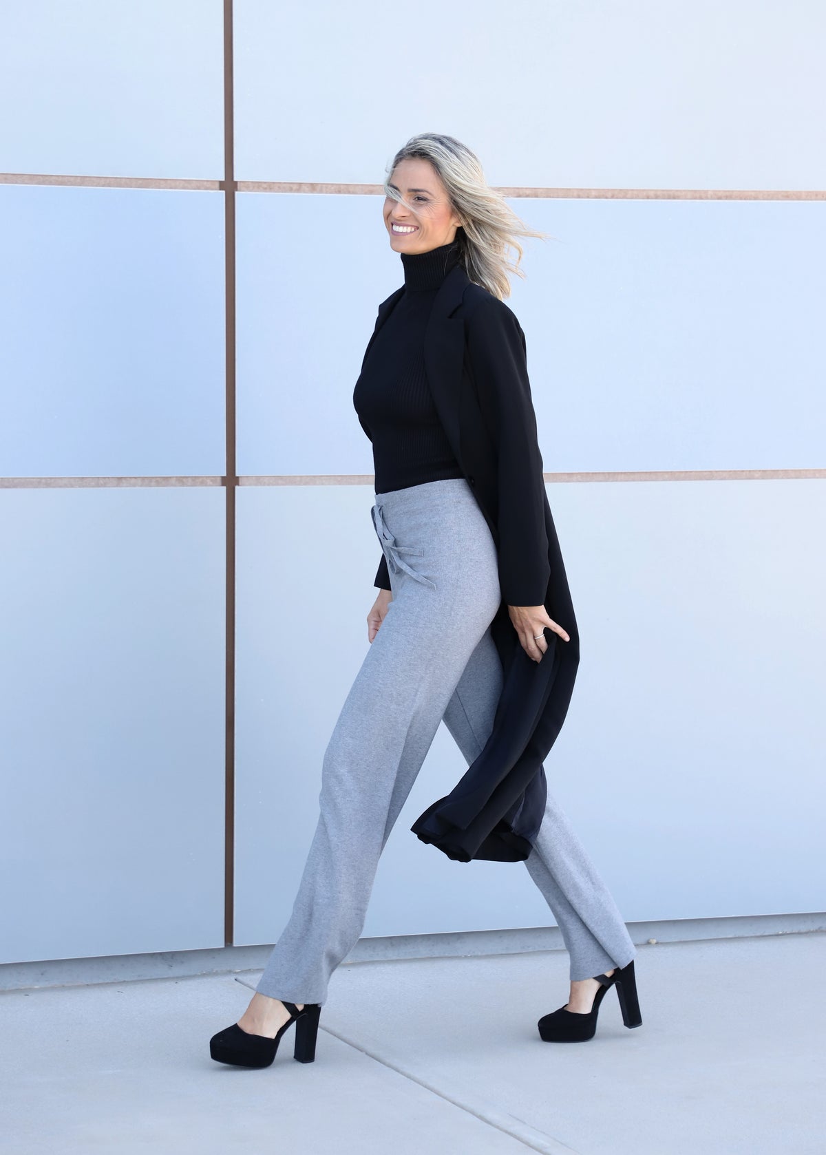 Side view of the VVC™ black longline blazer with a classic tailored cut, made in Greece.