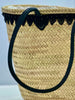 Close-up of the VVC Black Pearl beach basket with black handles, natural raffia weave and decorative black lace trim.