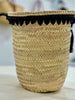 Side view of the VVC Black Pearl palm-leaf beach basket showing its natural woven texture and black lace edge.