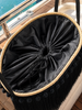 Bird’s-eye close-up of the VVC™ black satin fringe raffia basket showing its drawstring fall-out protection on a luxury yacht.