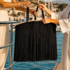 VVC™ oversized black satin fringe raffia basket close-up during a luxury yacht handover in the Mediterranean.