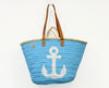 Front view of a handmade VVC™ blue beach basket with white anchor design and leather handles. Spacious shopping tote and beach bag inspired by Mediterranean coastal living.