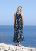 Full-length front view of the VVC blue-and-black floral sequin mullet evening dress beside the sea.