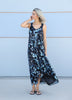 Side view of a model wearing the VVC blue-and-black floral sequin mullet dress, showing its shorter front and long flowing back.