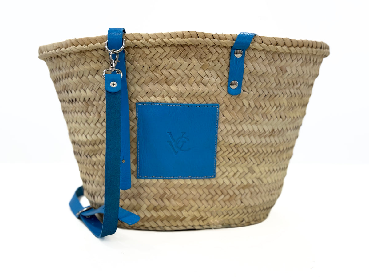 Back view of handmade VVC™ palm leaf basket featuring blue leather strap and artisan craftsmanship. Mediterranean shopping bag and beach basket available online and in Sitia, Crete.