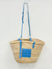 Front view of handmade VVC™ palm leaf crossbody basket with blue leather pocket and adjustable shoulder strap. Lightweight shopping bag and beach basket available in Sitia, Crete.