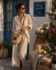 Woman wearing a handmade VVC™ crossbody palm leaf basket with brown leather details. Stylish Mediterranean beach bag, shopping tote and travel companion inspired by life in Crete.
