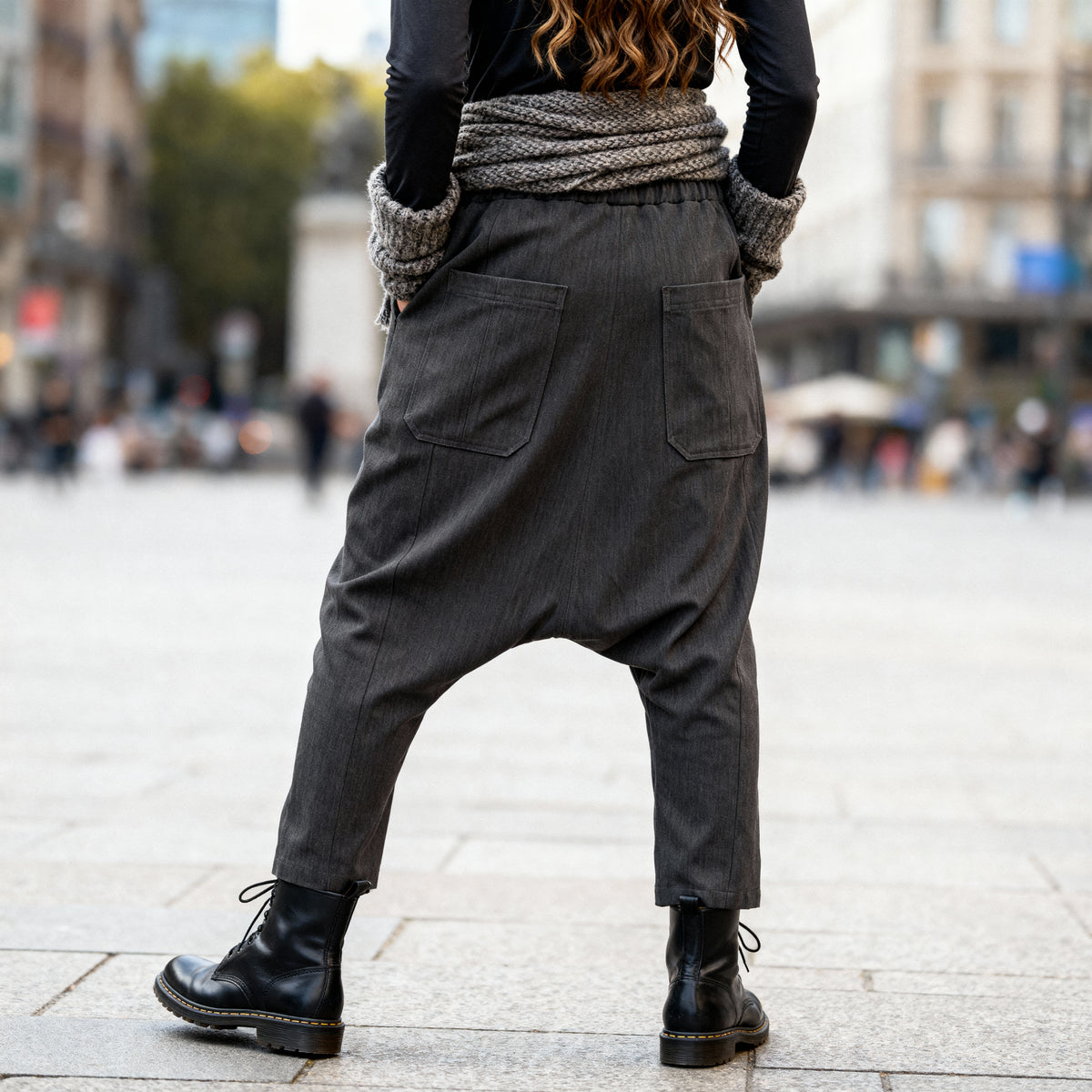 Close-up back view of VVC dark-grey striped harem trousers showing the rear pockets and low-crotch cut.
