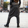 Close-up back view of VVC dark-grey striped harem trousers showing the rear pockets and low-crotch cut.