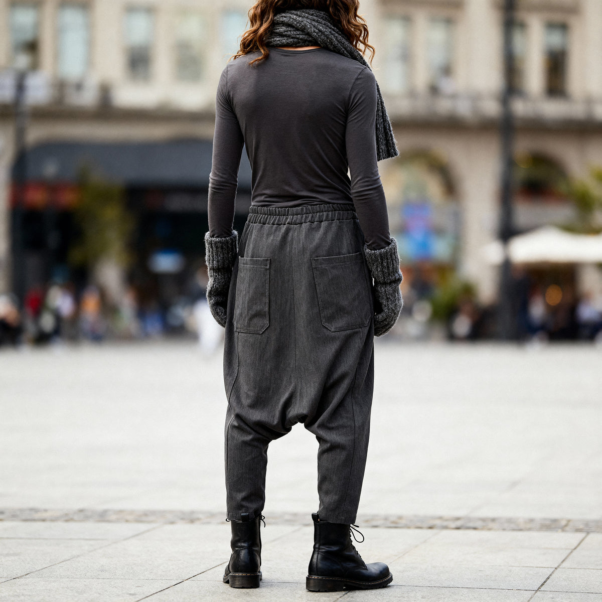 Back view of a woman wearing VVC dark-grey striped harem trousers with a relaxed low-crotch silhouette.