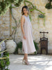 Woman wearing the VVC Flowing Blush Low-Back Midi Dress with metallic shoulder straps and soft viscose lining, made in Greece and photographed in Sitia, Crete.