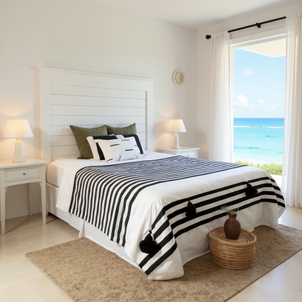 Handmade Moroccan cotton blanket by VVC with black woven stripes and off-white organic cotton, styled in a bright Mediterranean bedroom interior