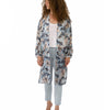 VVC Italian silk kimono with blue floral print styled with white top and light blue trousers on white background, elegant resort wear from VVC SHOP Sitia