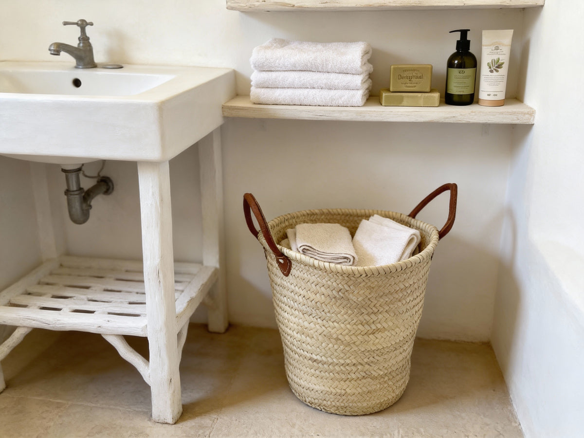 Side view of a large handmade natural palm leaf basket with camel brown leather handles by VVC.