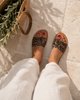 Looking-down view of VVC™ leopard print leather sandals styled with white linen on pale stone in Crete, casual summer fashion from VVC SHOP Sitia