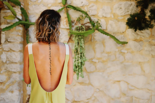 Close-up of the deep scoop back, gold metallic straps and decorative pleats on the VVC lime green dress in Sitia, Crete