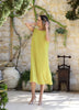 Woman wearing the VVC lime green low-back midi dress with metallic gold straps in Sitia, Crete