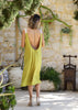 Back view of the VVC lime green midi dress showing the deep open back and metallic shoulder straps