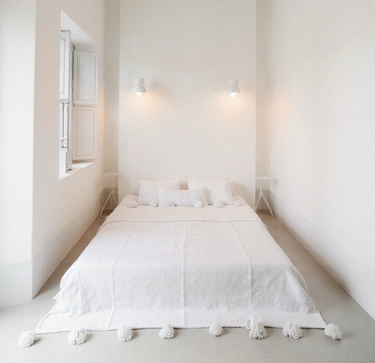 Front view of VVC™ organic cotton blanket in white and small handmade in Morocco with decorative pompoms.