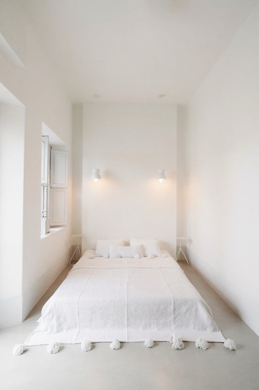 Front view of VVC™ organic cotton blanket in white and small handmade in Morocco with decorative pompoms.