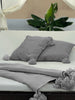 Dark gray organic cotton blanket by VVC™ styled in modern outdoor bed, made in Morocco.