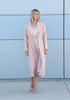 Front view of a pale-pink VVC velour women’s coat showing its button closure and knee-length cut.