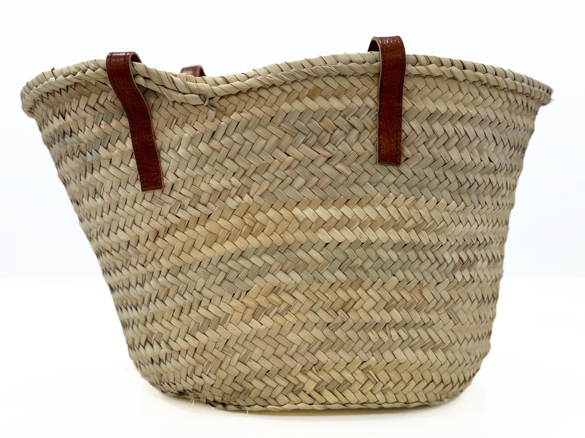 Back view of the VVC™ handmade palm leaf basket showcasing natural woven craftsmanship, leather handles and timeless Mediterranean style for shopping, travel, storage and everyday use.