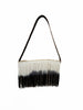 Back view of a handmade VVC raffia shoulder bag featuring long black and white ombré fringes, natural raffia construction and a leather shoulder strap.