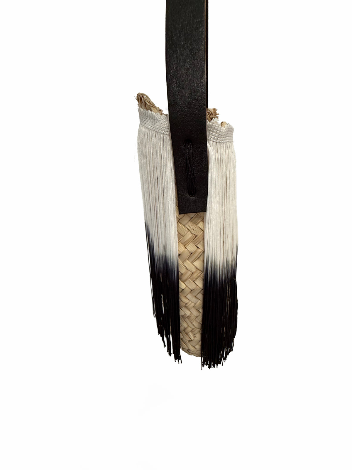 Side detail of VVC raffia fringe bag showing black and white ombré fringes, natural raffia body and leather strap