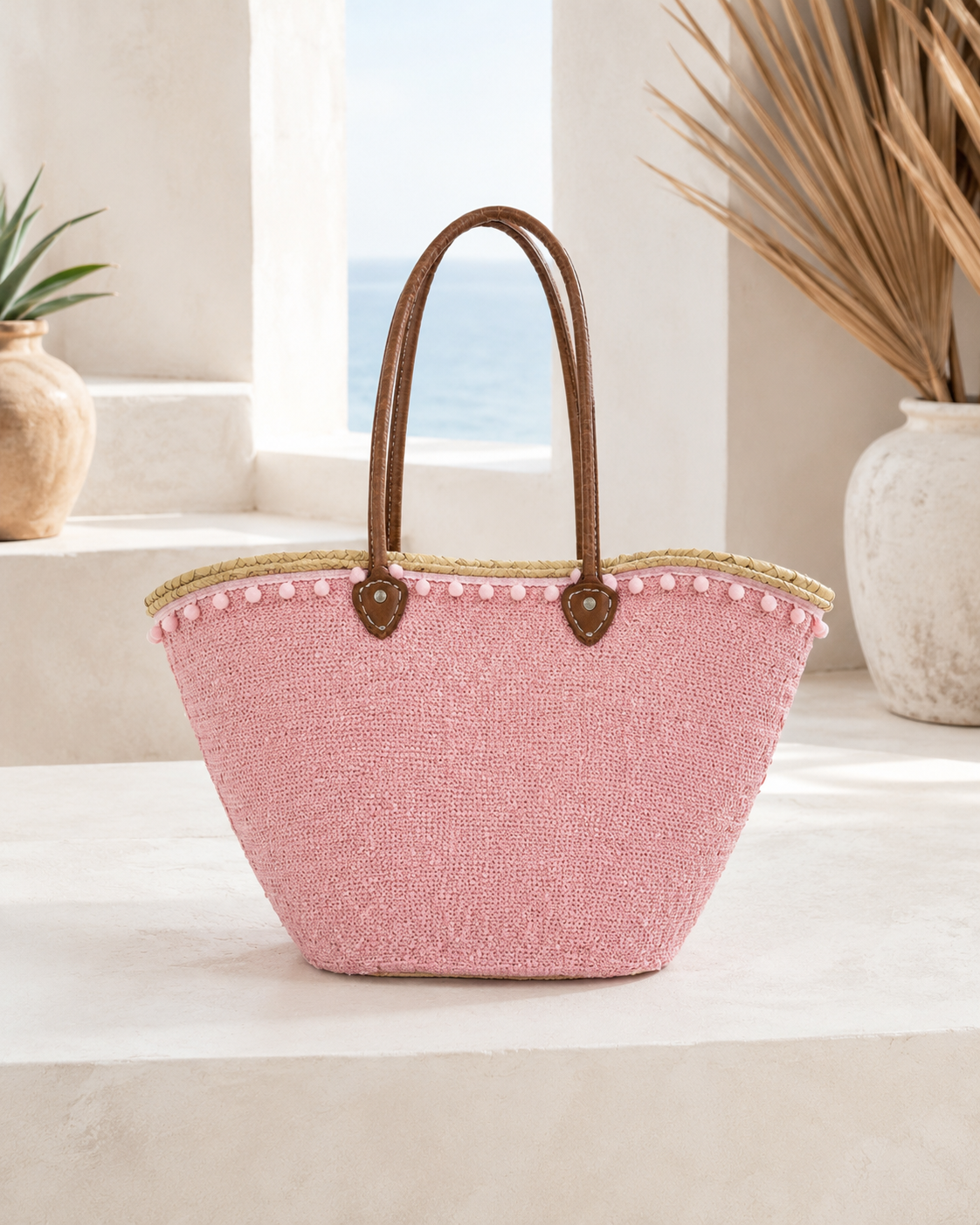 Back view of a handmade VVC soft pink sequin basket featuring brown leather handles, natural palm leaf construction and artisan craftsmanship. Large boho-style beach and shopping basket with approximately 100 litres carrying capacity.